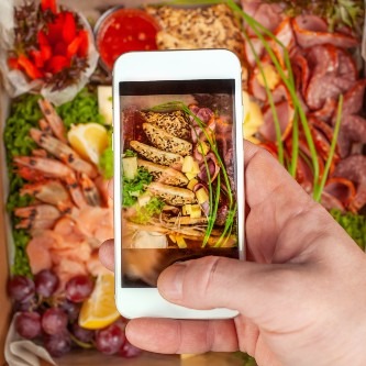 a-man-takes-pictures-of-food-on-his-phone-shrimp-2023-11-27-05-19-27-utc